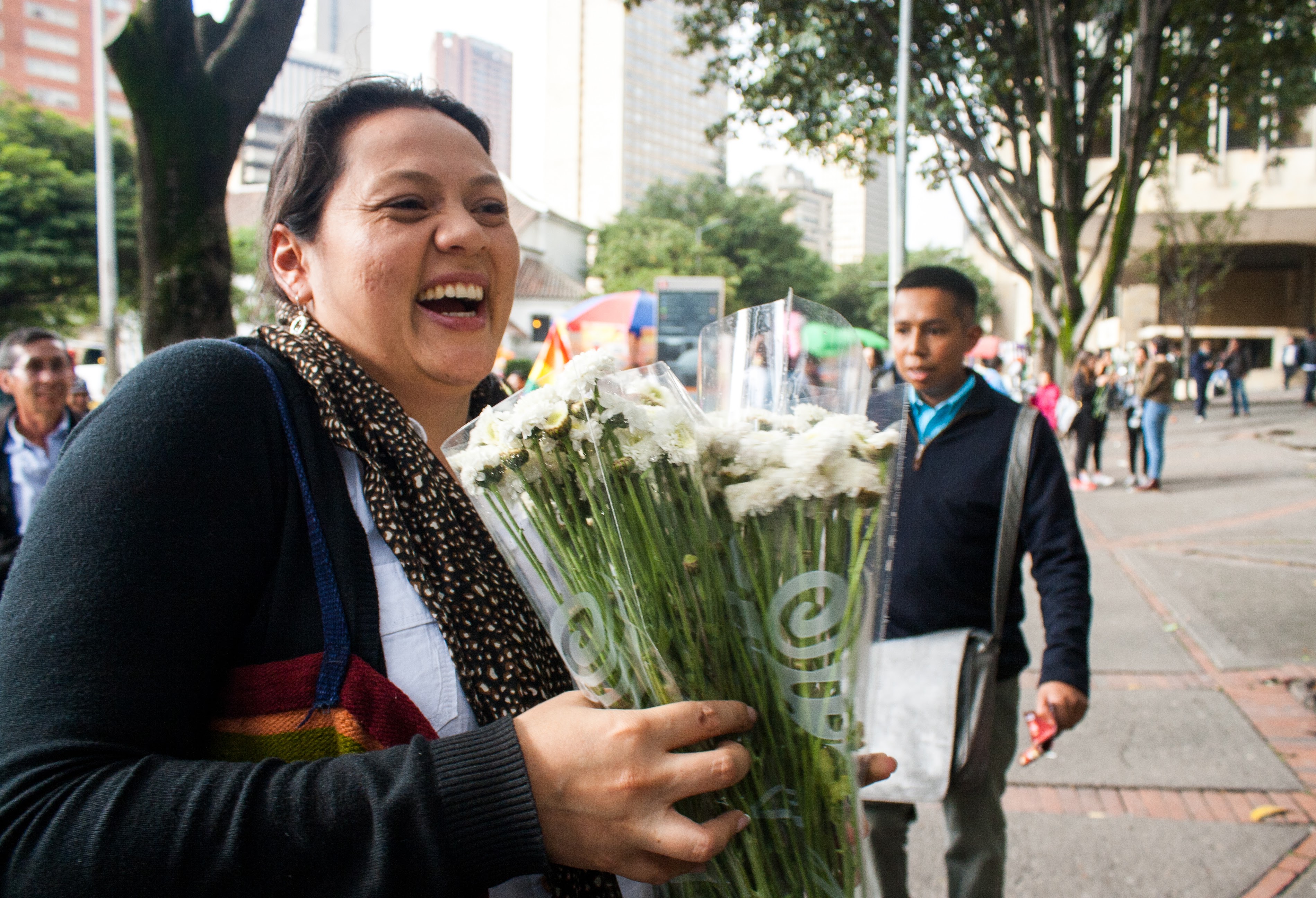 Angelica Rincon, a member of the Mennonite church buys flowers to give to the victims arriving in Bogota to demand a peace accord after the plebiscite. Anna Vogt. 