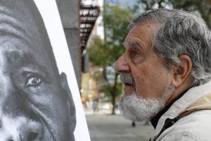 A man examines one of the cholera victim portraits installed by MCC and partners. Bea Lindstrom.